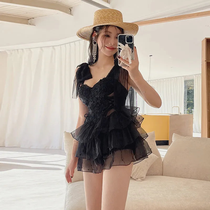 Black sleeveless one-piece swimsuit with a gathered chest design on a mannequin.