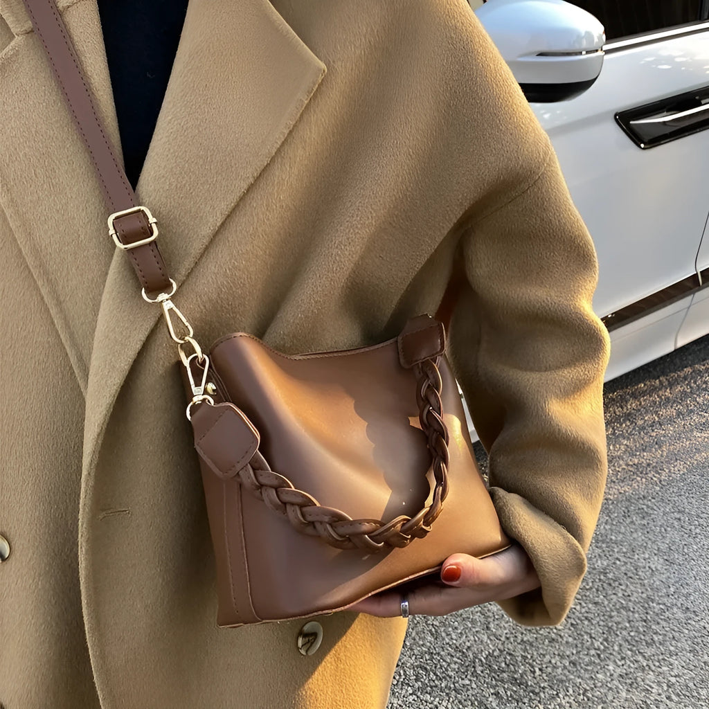 Woven texture PU leather crossbody bucket bag in neutral colour showing one-shoulder underarm carrying design