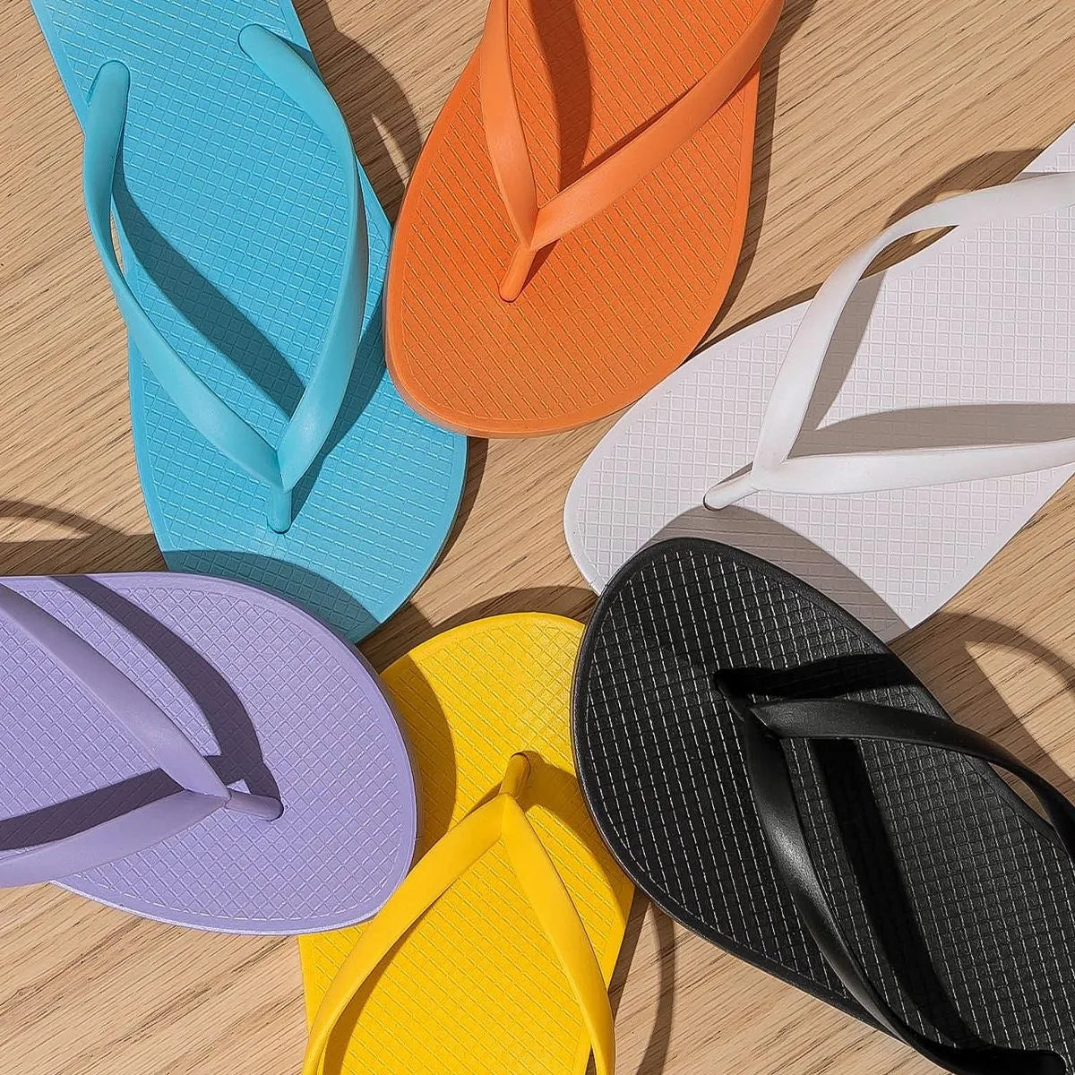 Flat casual slipper with hollow-out plastic upper and textured PVC sole in orange colour.