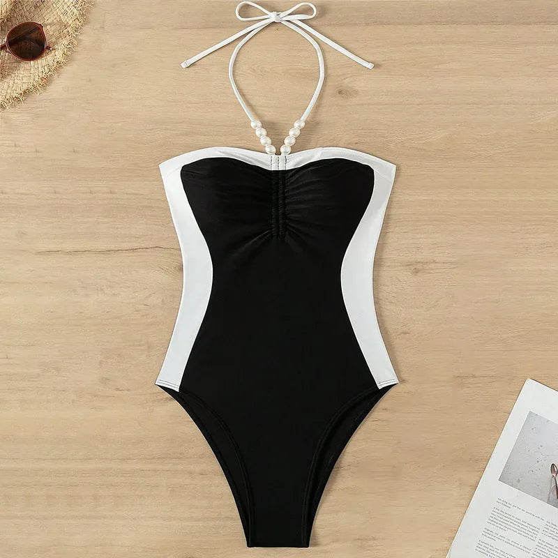 Women's black and white pearl spaghetti strap one-piece swimsuit with sleeveless slimming design.