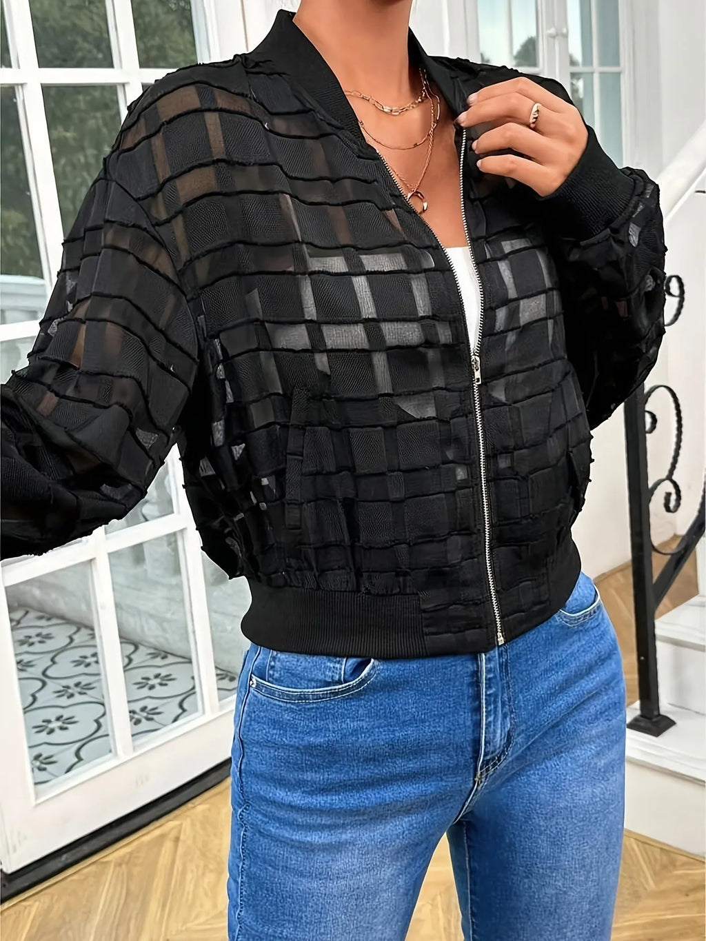 Black women's casual jacket with geometric pattern, full zip, and long sleeves on a hanger.