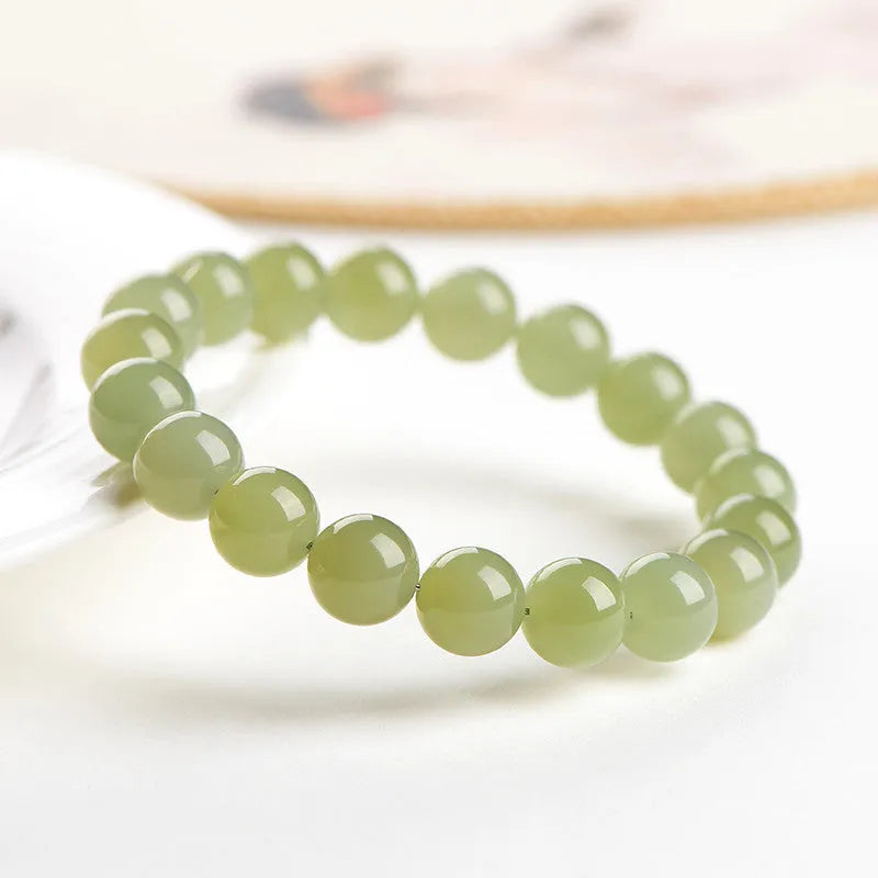 Polished Hetian jade ball bracelet showing spherical beads on a wrist, available in deep or shallow ice-clear colours.