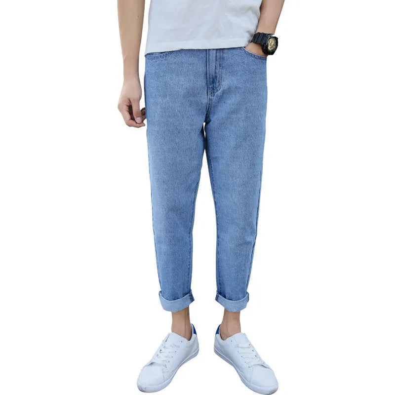 Man wearing loose straight leg cotton jeans in blue, showcasing the light straight open leg style.