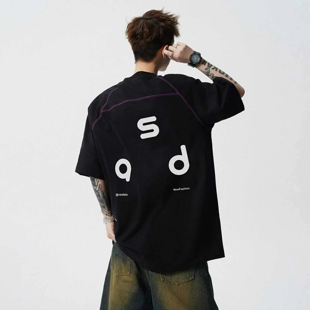 Man wearing a loose fit black cotton t-shirt with a letter print on the chest.