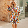 Orange floral print mini dress with V-neck, long sleeves, and striped lace detailing