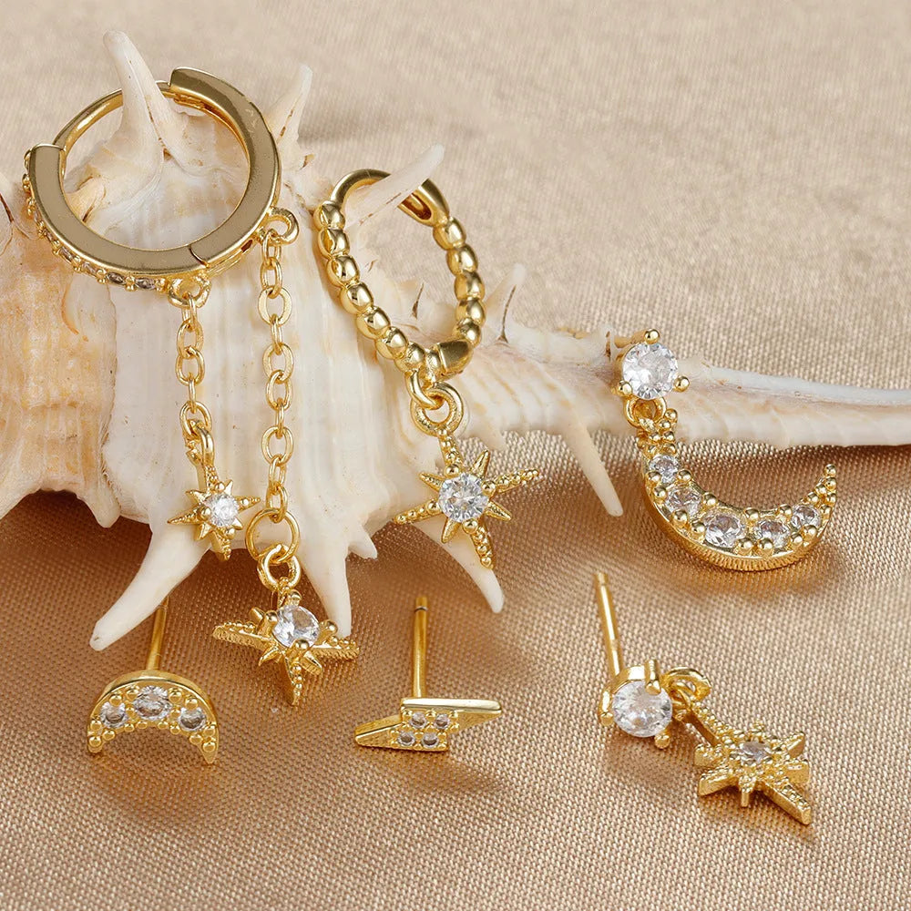 Six pairs of gold chain tassel earrings with zircon stones arranged in display