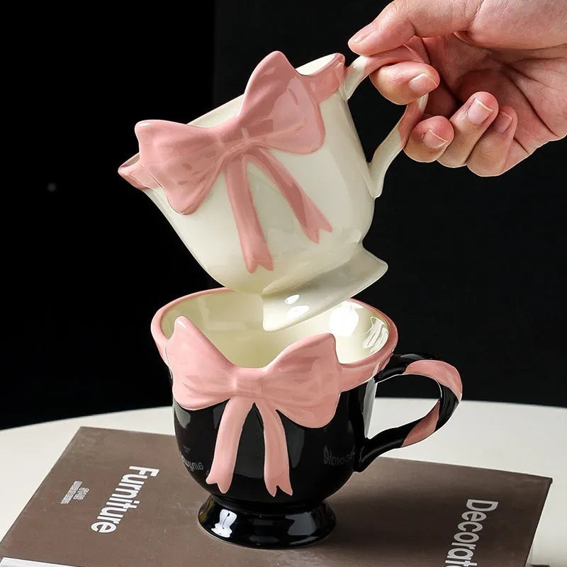 Ceramic mug with heart and bow design in white or black pink colours