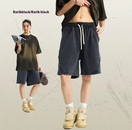 Man wearing loose-fit batik washed cotton terry shorts in a retro style with patch craft details.