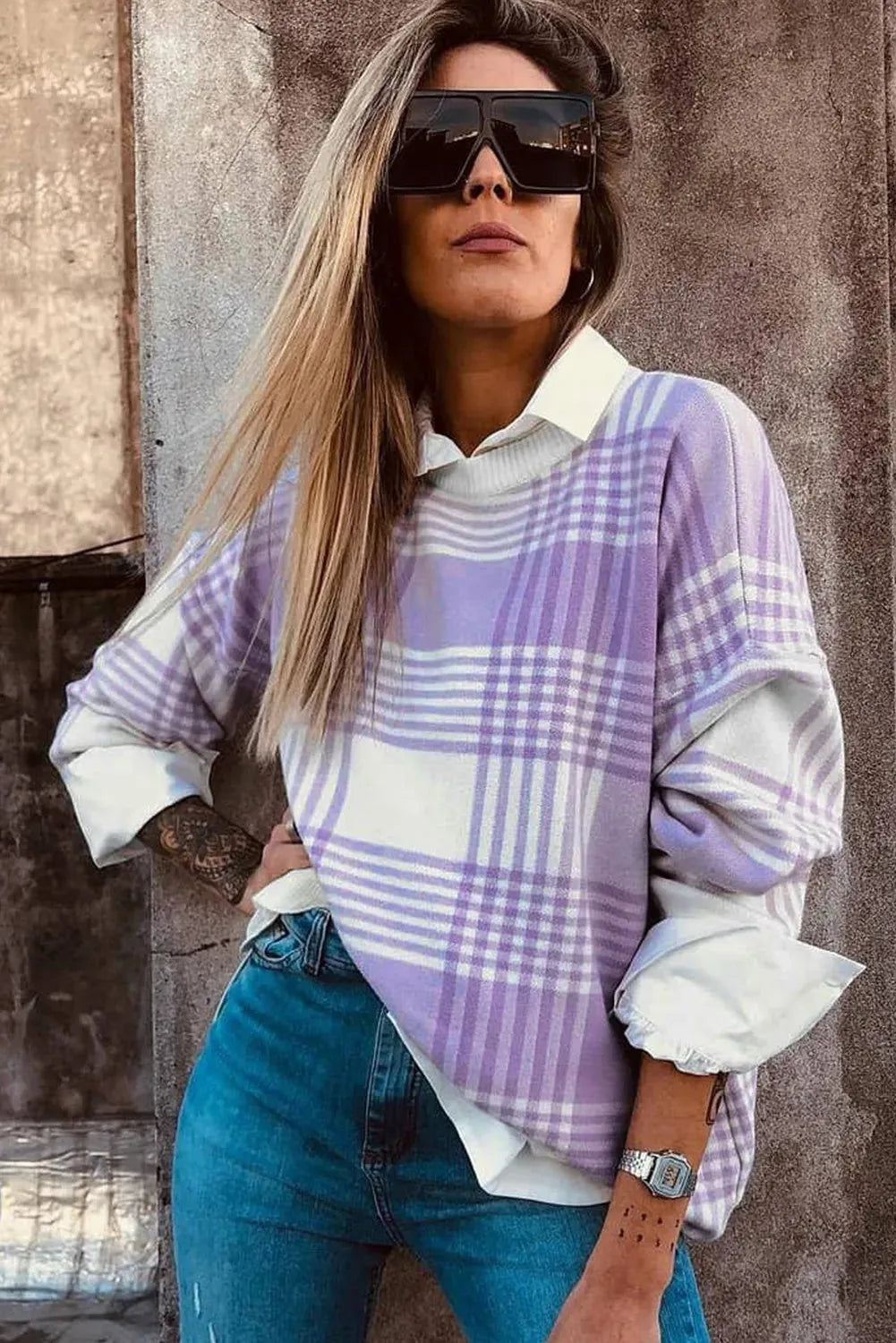 Lilac plaid print loose sweater with ribbed cuffs and collar on a hanger.
