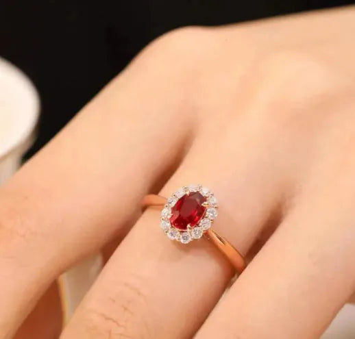 Women's silver ring with gold pigeon design and red artificial gemstone centre.