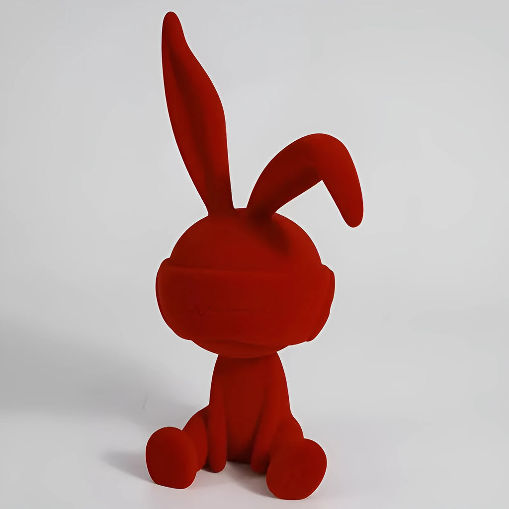 Green suede blindfold rabbit resin table ornament on a wooden desk