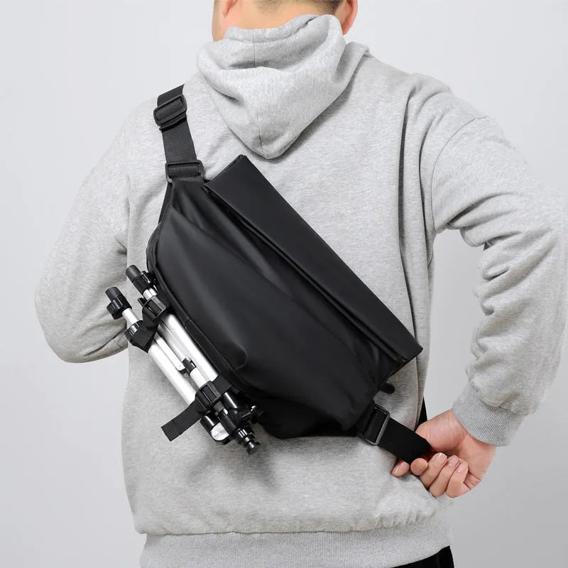 Grey horizontal square crossbody bag for men with a single shoulder strap and zipper.