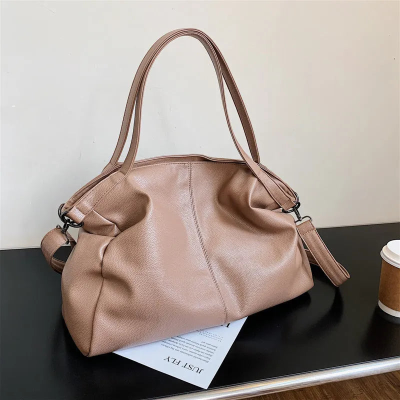 Large soft surface PU messenger bag in horizontal square shape with zip opening and shoulder strap.