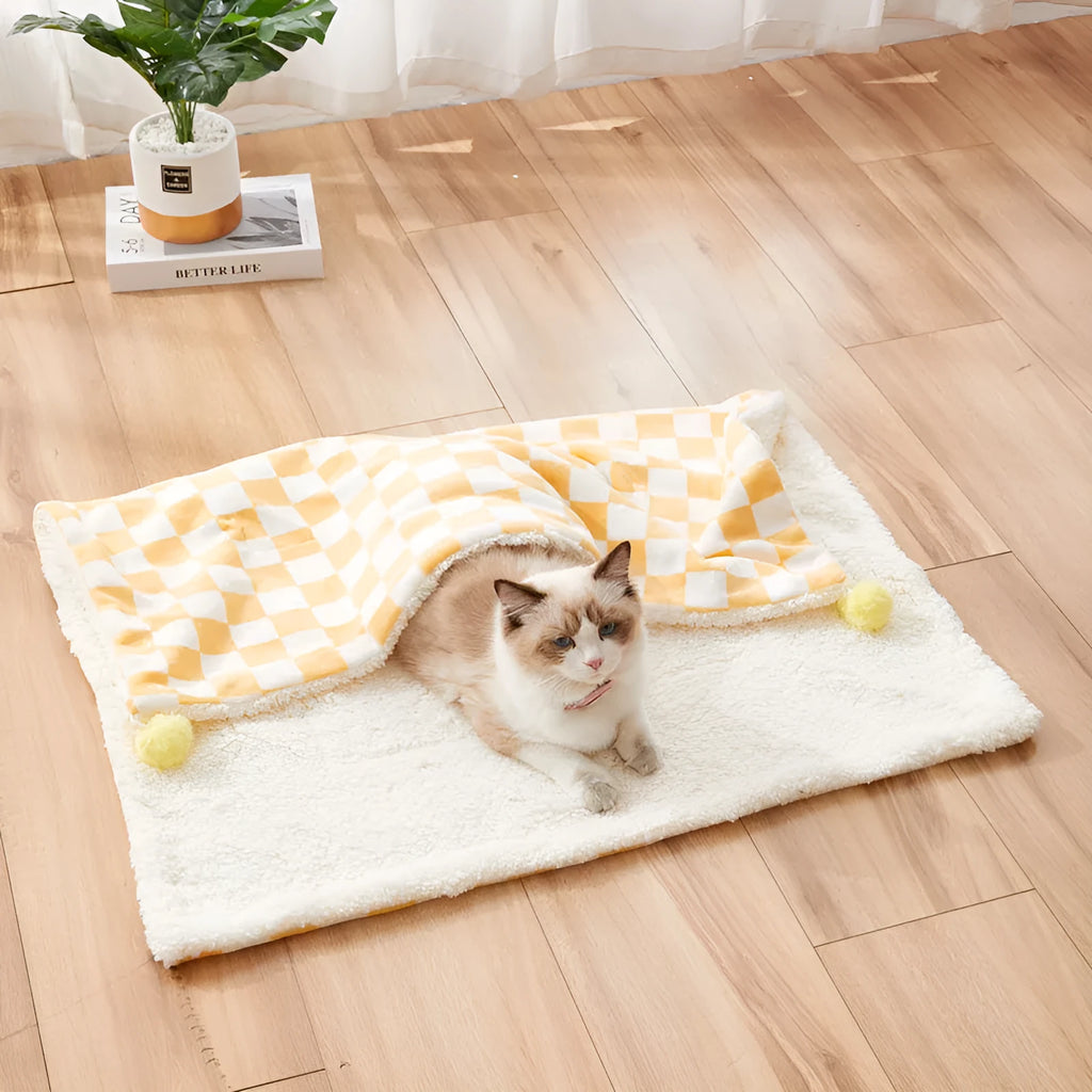Plush pet blanket with bright plaid pattern and fur ball decorations for cats and dogs