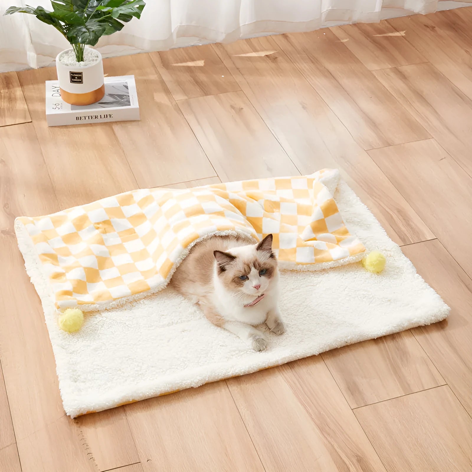 Plush pet blanket with bright plaid pattern and fur ball decorations for cats and dogs