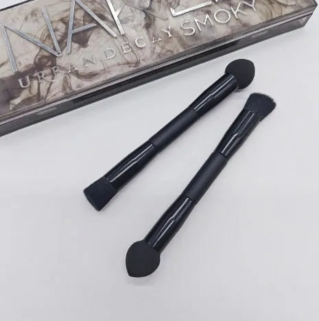 Double-headed makeup brush with black sponge end and pointed brush end on wooden handle