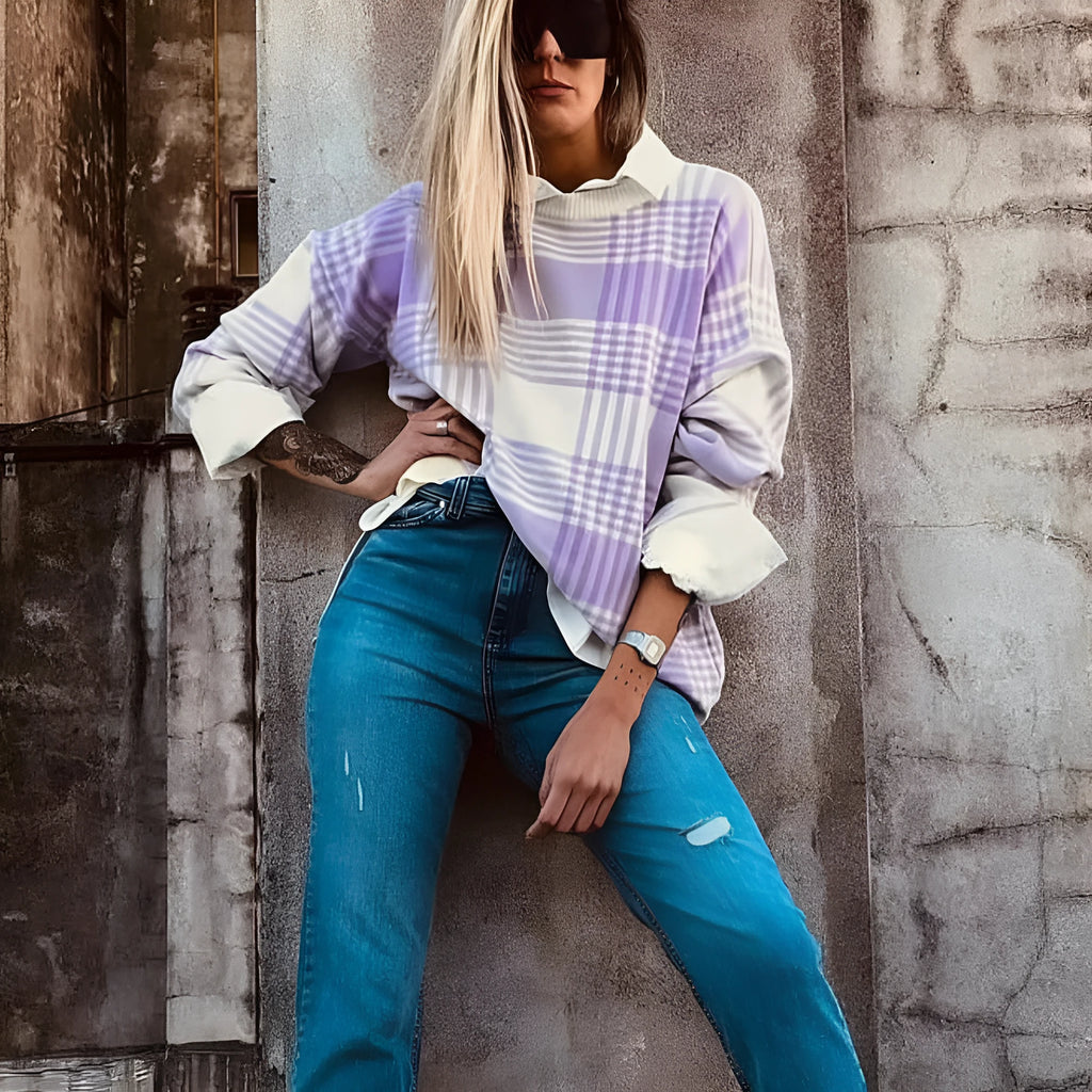 Lilac plaid print loose sweater with ribbed cuffs and collar on a hanger.