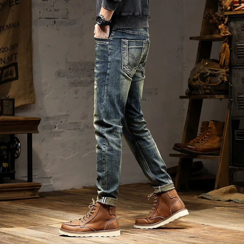 Men's skinny fit retro blue jeans with a high waist and zip fly on a plain background.