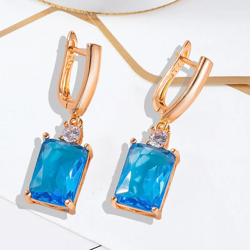 A pair of square, geometric earrings with a gold electroplated finish on a copper base.