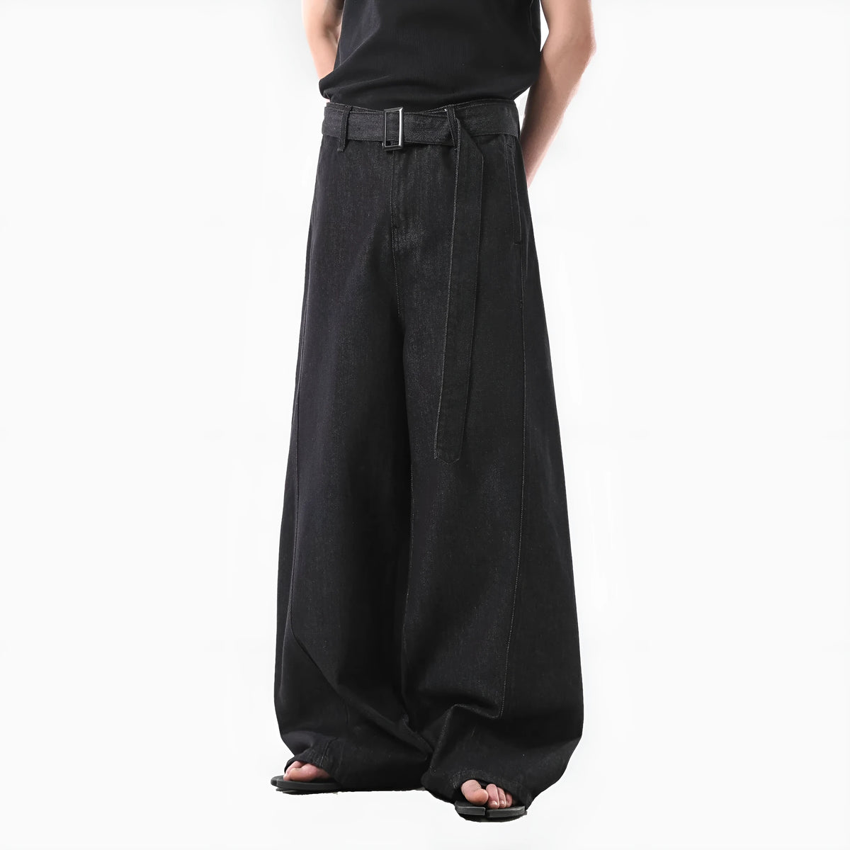 Black high-waist straight-leg jeans with gold details on a denim background.