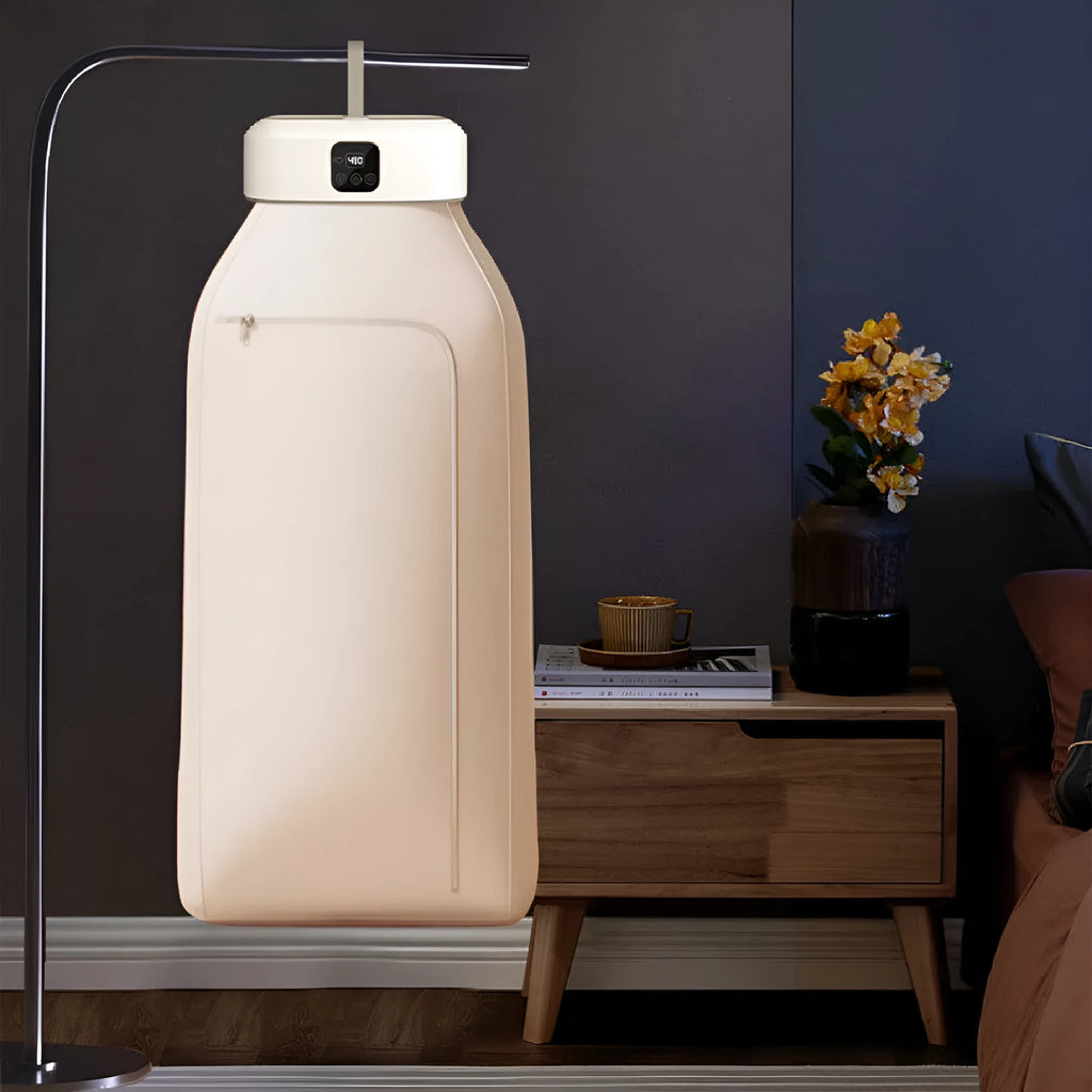 White cylindrical compact laundry dryer with remote control on countertop