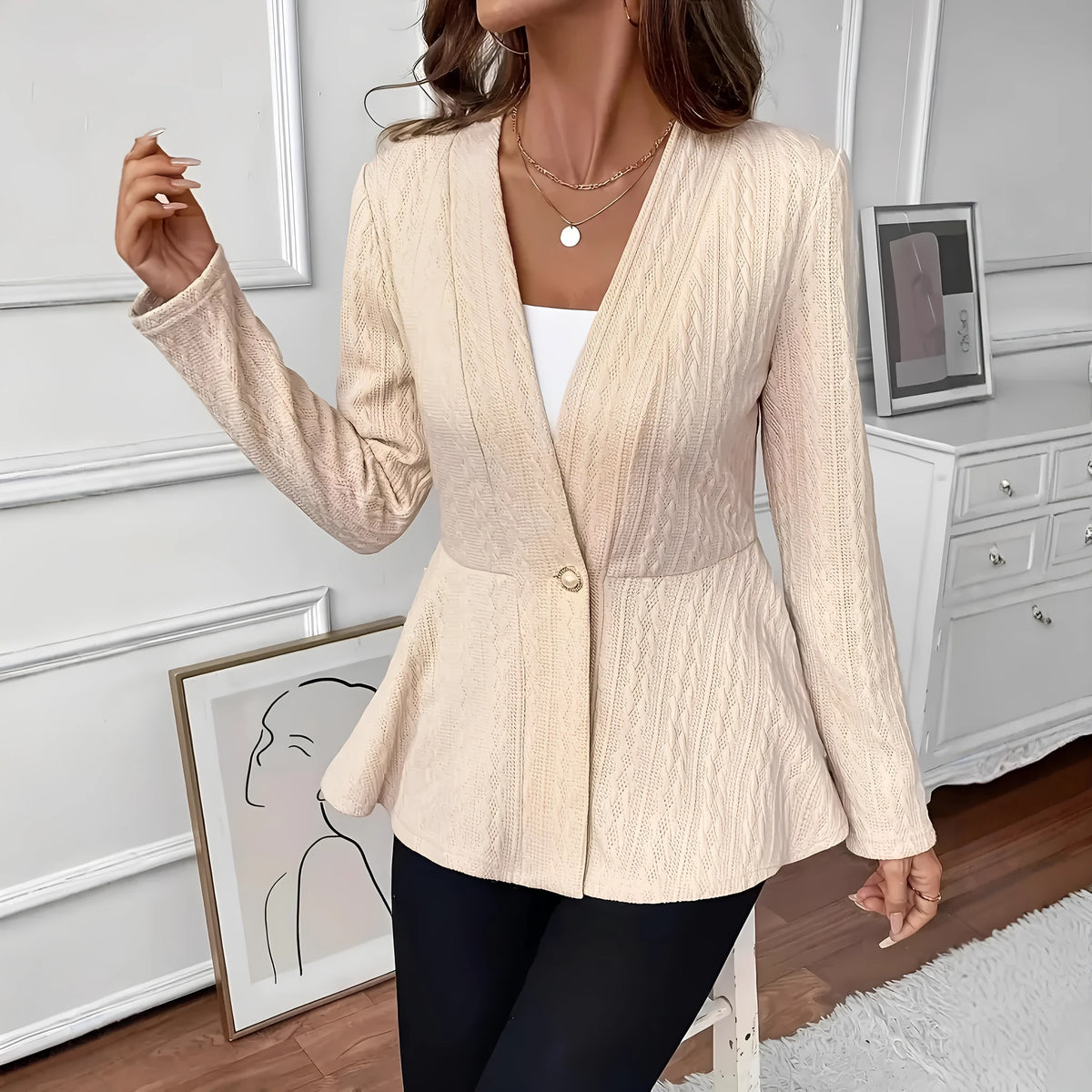 Women's apricot knitted cardigan with one button and jacquard pattern on a hanger.