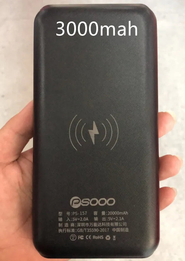 Black portable power bank with wireless Qi charging pad, three USB ports, and LED flashlight