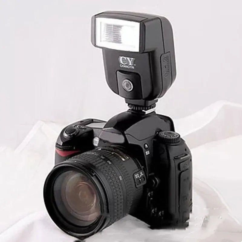 Compact silver SLR camera flash with a rotating head on a hot shoe mount