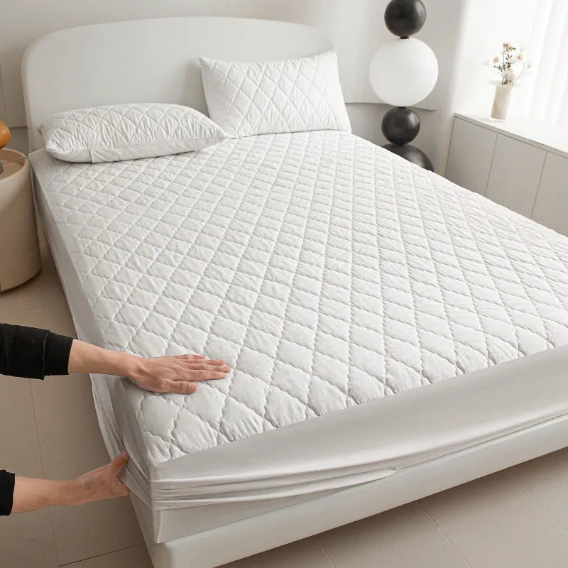 Diamond lattice quilted waterproof mattress protector fitted sheet in a solid colour on a bed.