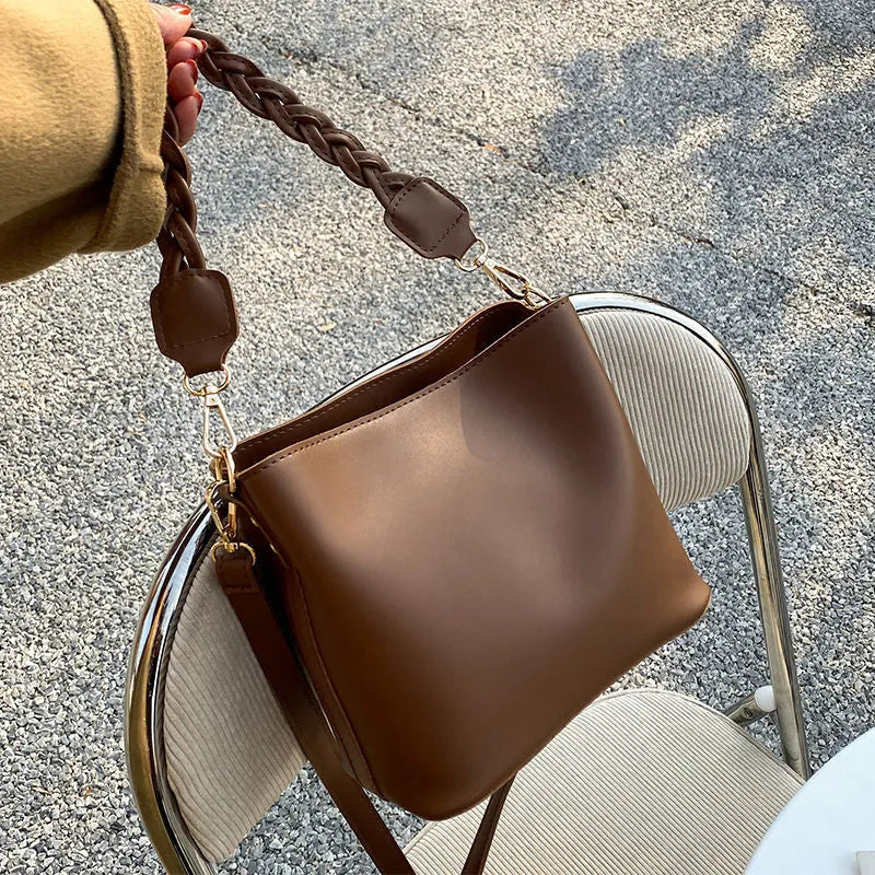 Woven texture PU leather crossbody bucket bag in neutral colour showing one-shoulder underarm carrying design