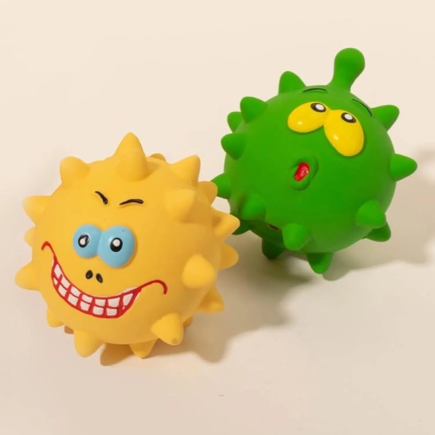 Set of four colourful natural latex squeaky dog balls with cute faces, shown with a dog.