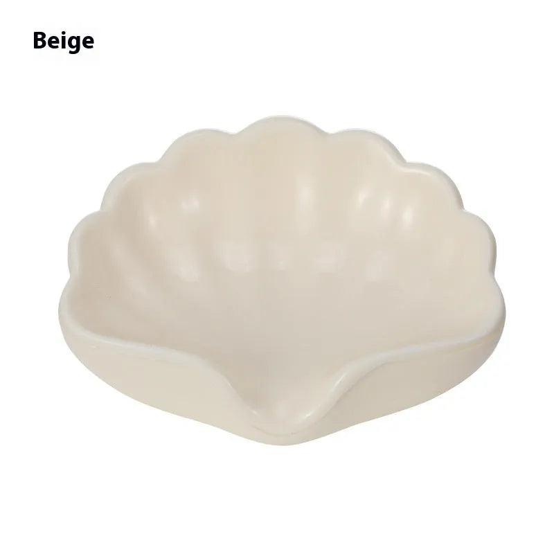White and pink shell-shaped plastic soap dish on a bathroom countertop