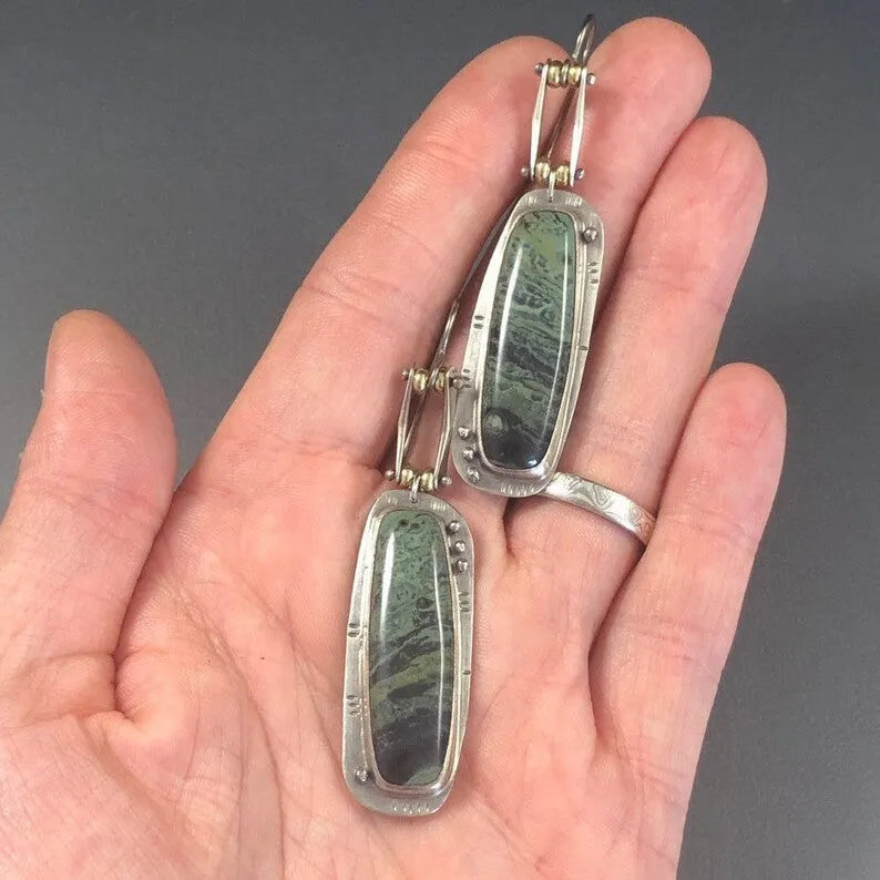 A pair of geometric-shaped alloy earrings with a black and white marble pattern print.