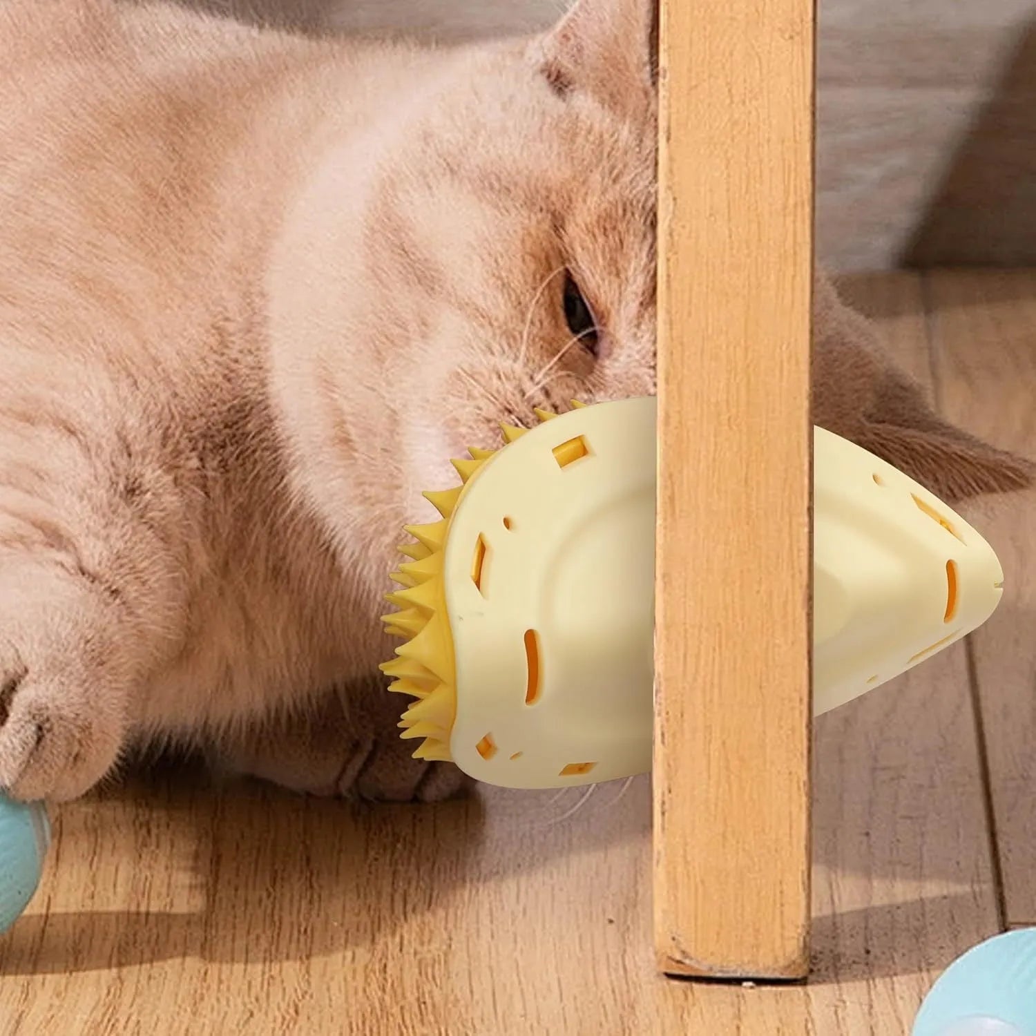 Yellow durian-shaped cat corner scratcher and grooming toy mounted on a wall.