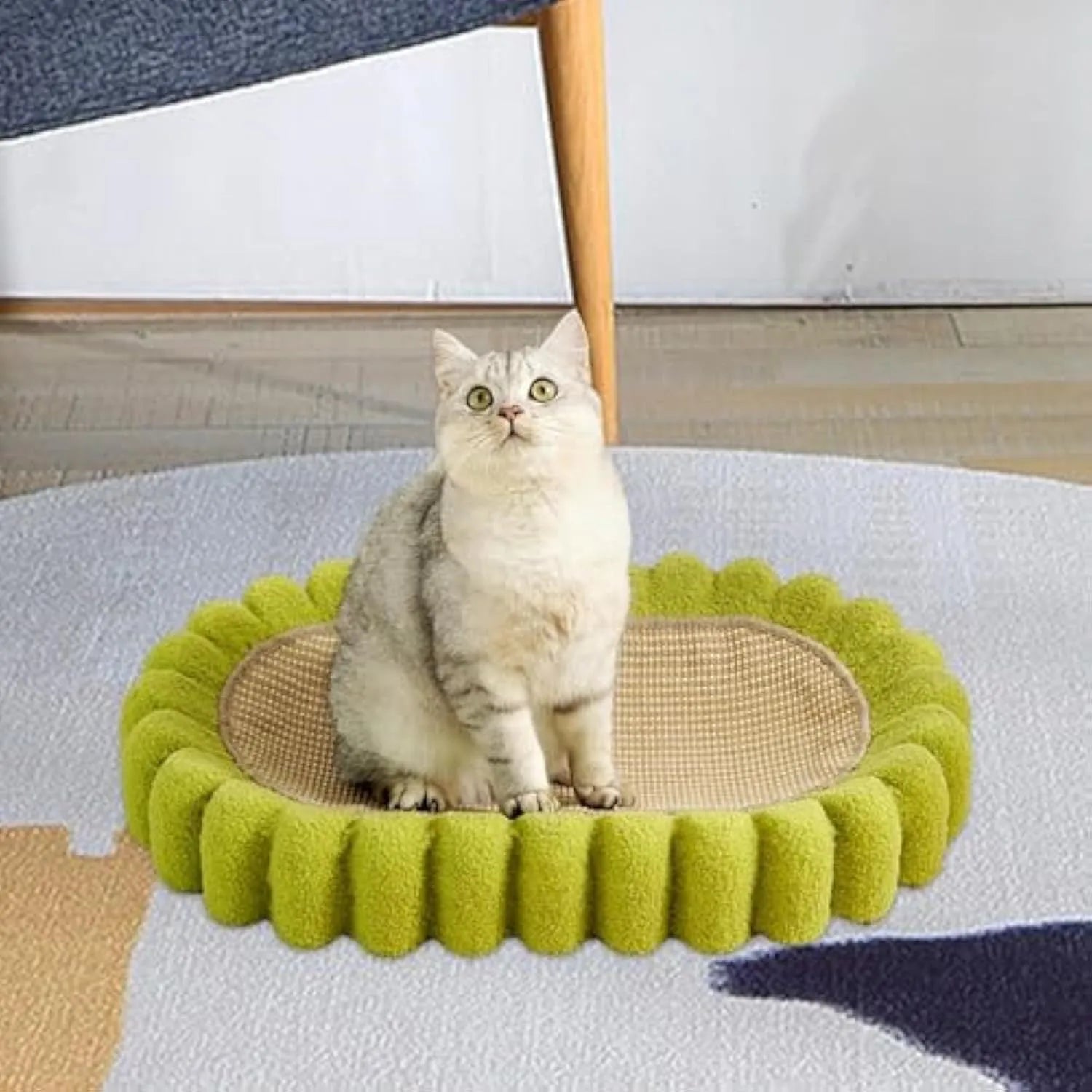 Green oval-shaped sisal cat scratching pad lounge bed on a floor.