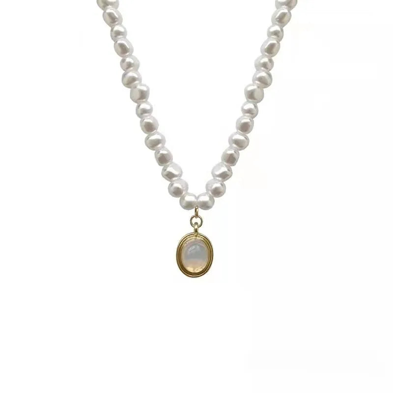 Vintage pearl necklace with geometric pendant on adjustable chain.