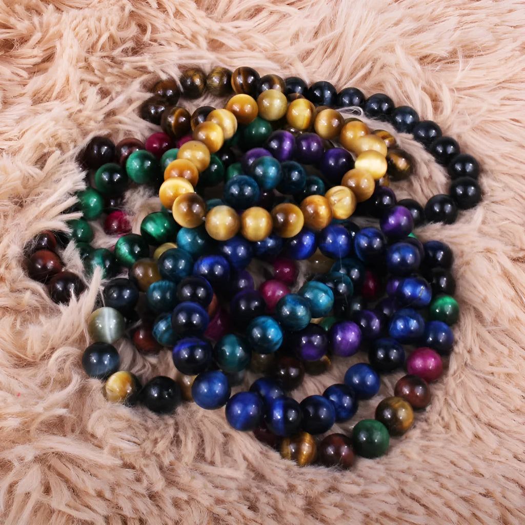 Natural tigereye crystal beaded bracelet with round beads, shown in a selection of colours and sizes on a wrist.