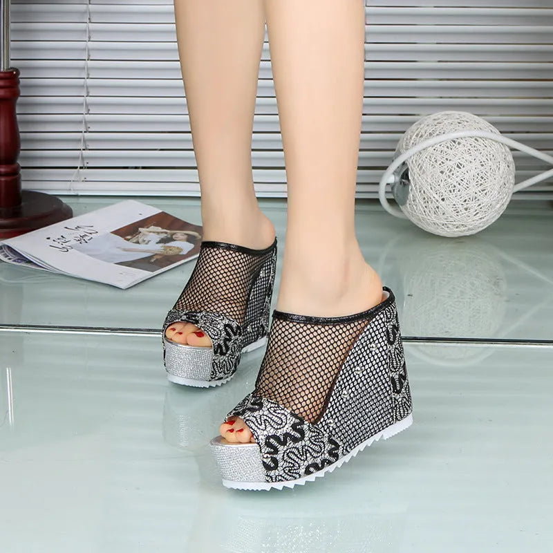 Women's black platform sandals with a lace-up ankle strap and hollowed-out chunky heel.