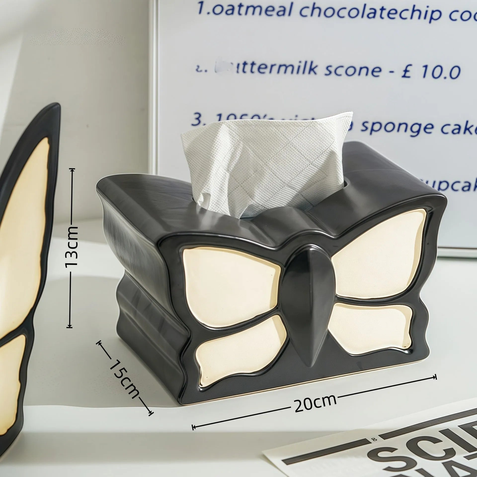 Ceramic butterfly vase and matching tissue box set on a living room table.