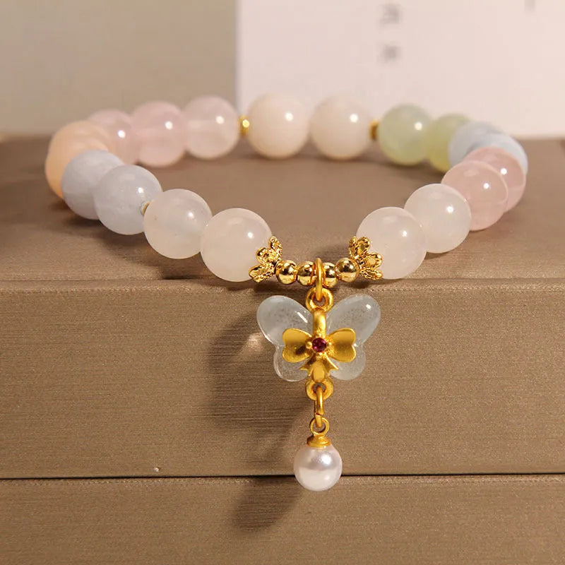 Close-up of a women's adjustable crystal bracelet with a colourful Morganite butterfly pendant.