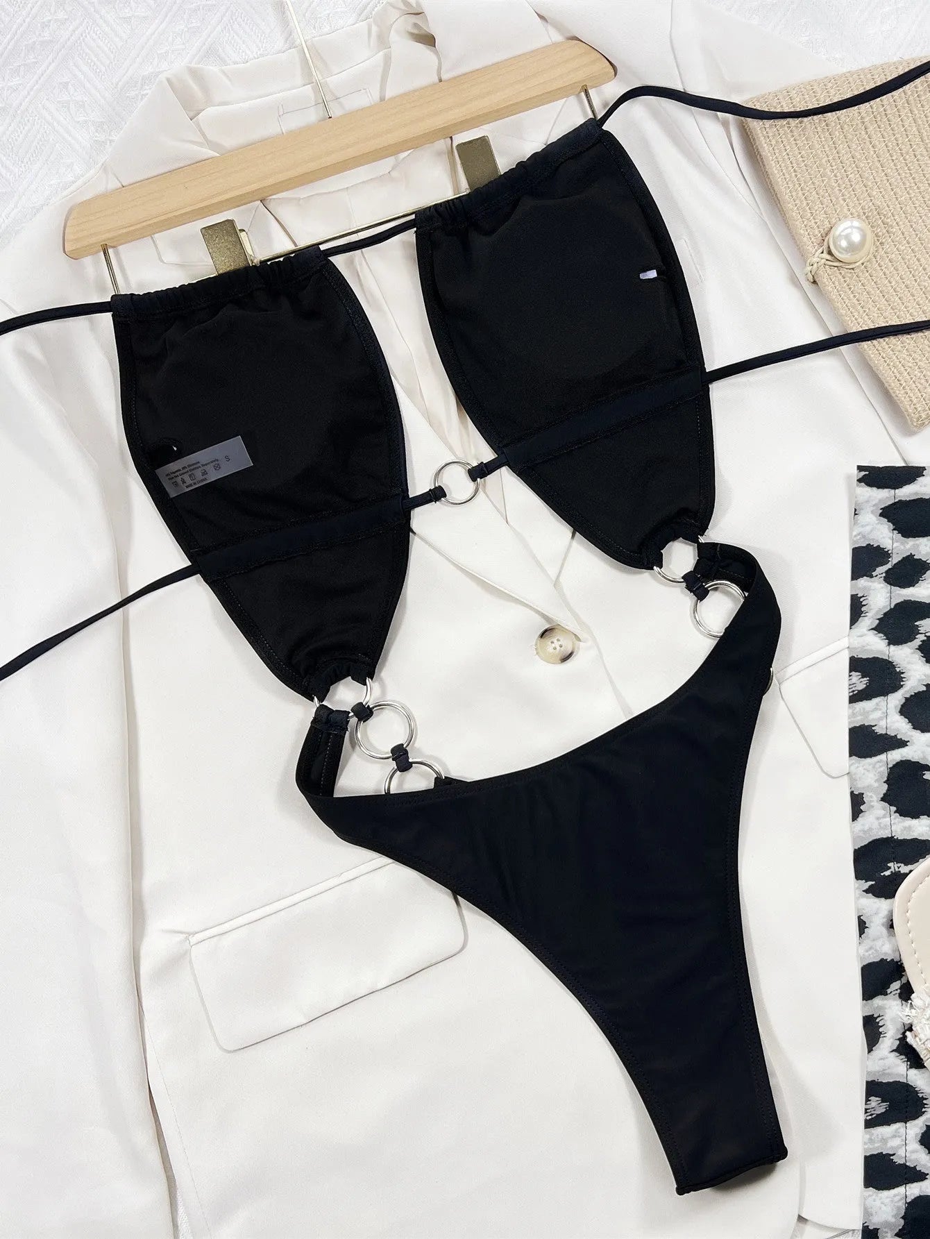 Black sleeveless one-piece swimsuit for women on a hanger.