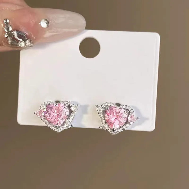 A pair of women's heart-shaped stud earrings with a white K electroplated finish on a copper base.