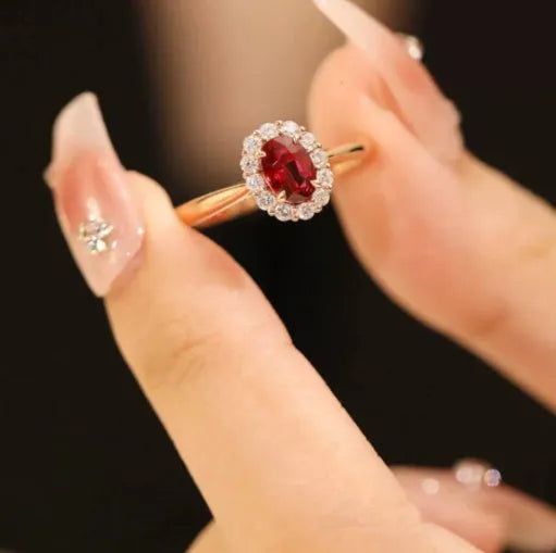 Women's silver ring with gold pigeon design and red artificial gemstone centre.