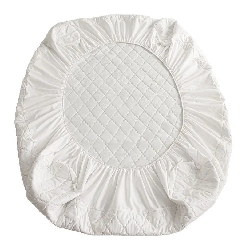 Diamond lattice quilted waterproof mattress protector fitted sheet in a solid colour on a bed.