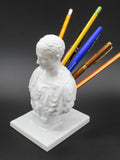 White American style character model pen holder made from synthetic resin on a desk.