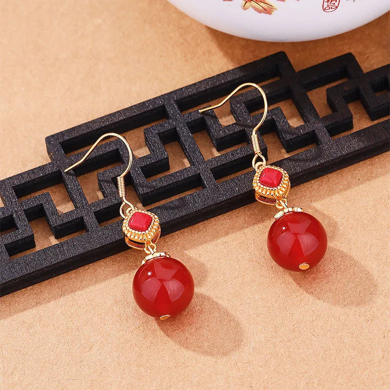 Geometric silver-plated earrings with round red agate beads and green jasper stone inlays.