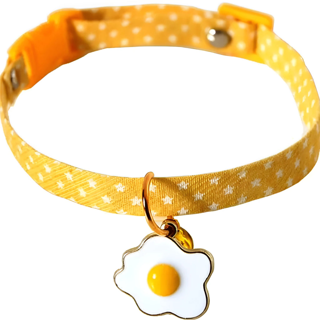 Green adjustable cat collar with a small bell and bow tie pendant on a white background.