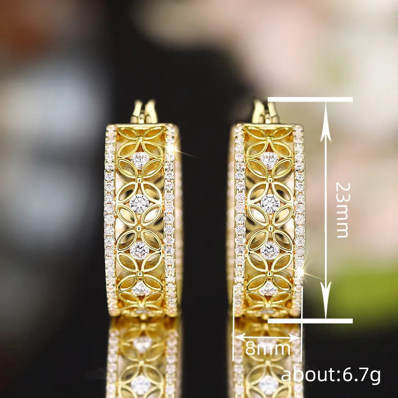 A pair of geometric copper ear clips with horse eye, flower and butterfly motifs in a yellow gold colour.