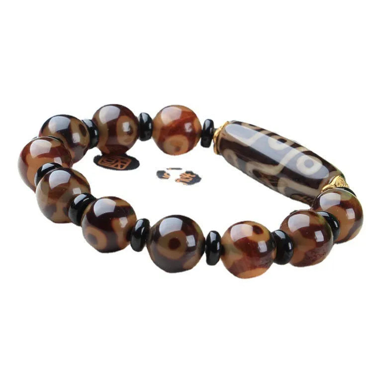 Distressed agate Tibetan bead bracelet with three-eye motifs and polished finish.