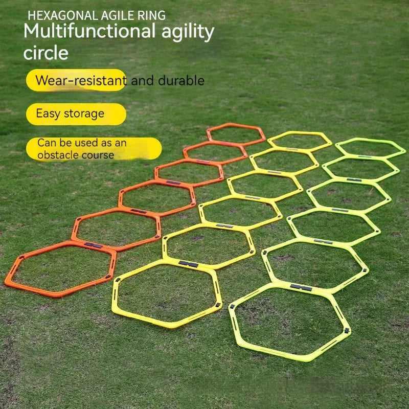 Set of six foldable yellow green and orange hexagon plastic agility training rings laid out on grass